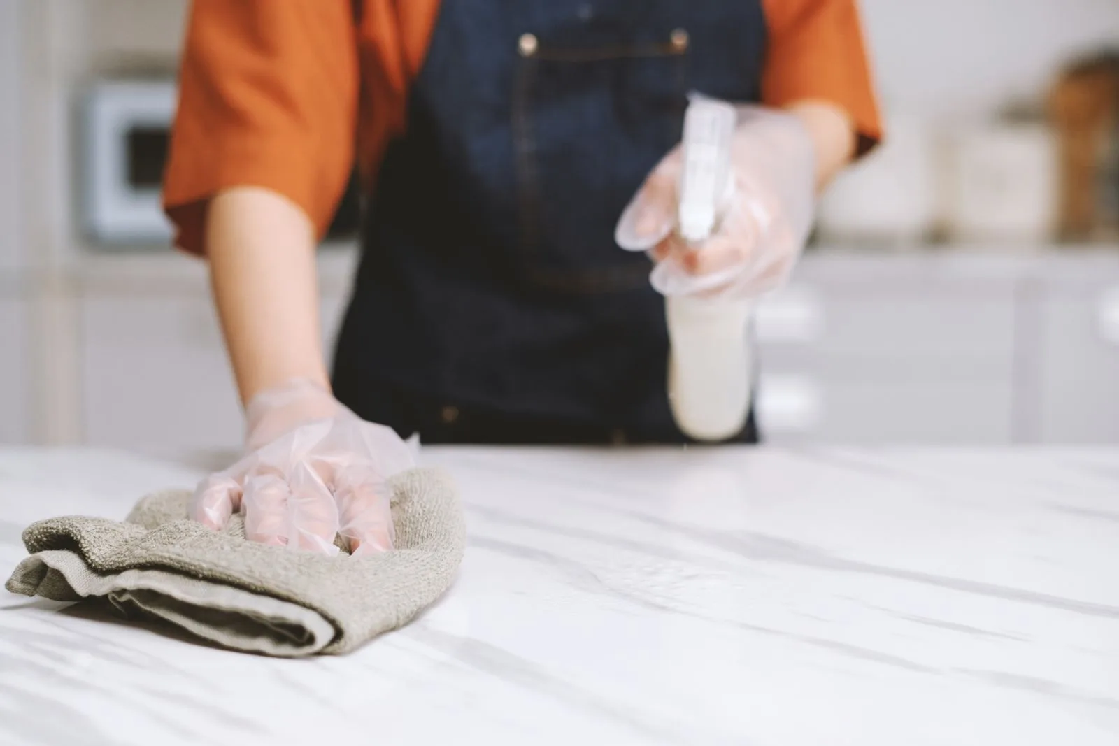 person cleaning marble worktops with damp wascloth