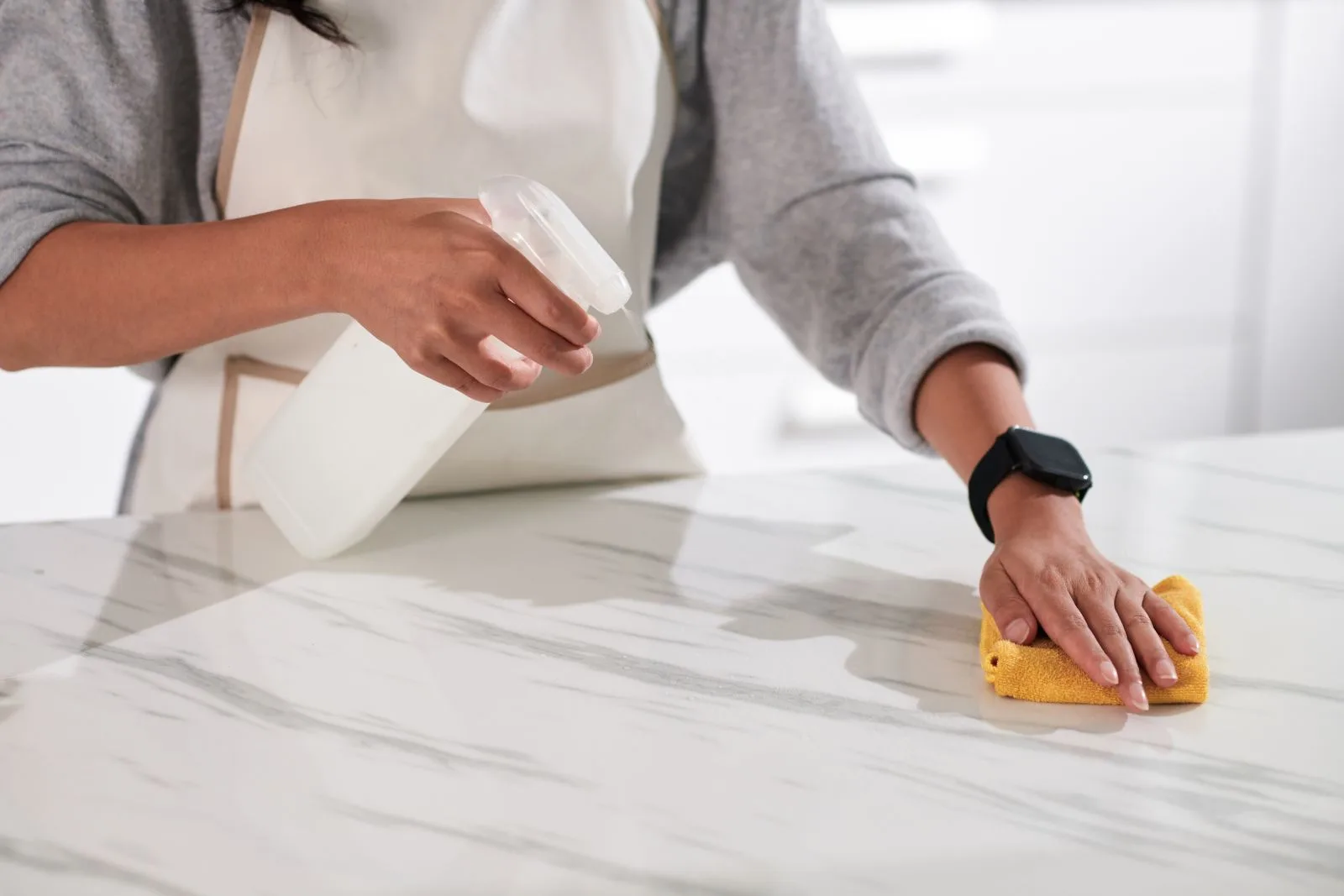 person cleaning marble worktops